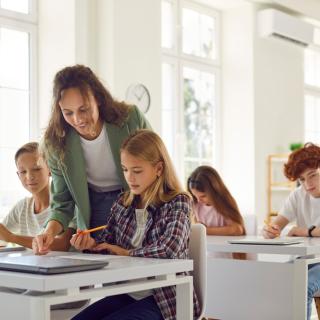 picture of teacher helping students in a classroom