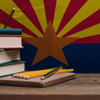 textbooks and pencils in front of arizona state flag